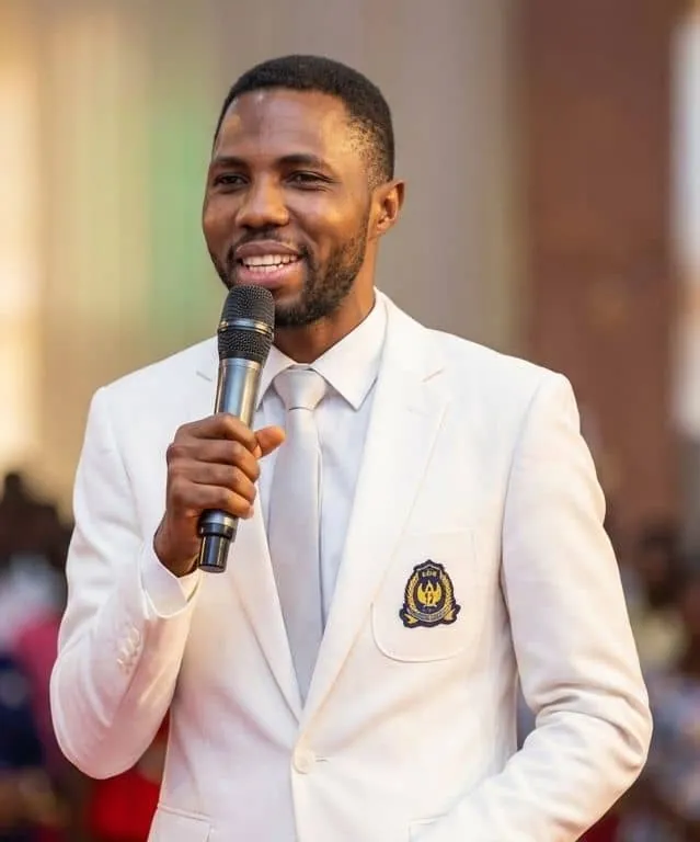 Pastor Henry Ikechukwu speaking with a microphone